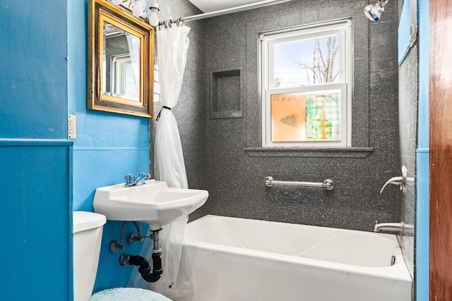 bathroom featuring toilet and shower / bath combo with shower curtain