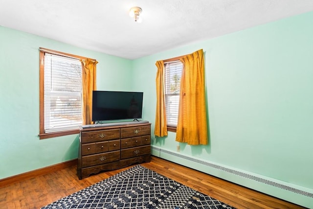 bedroom featuring a baseboard radiator and hardwood / wood-style floors