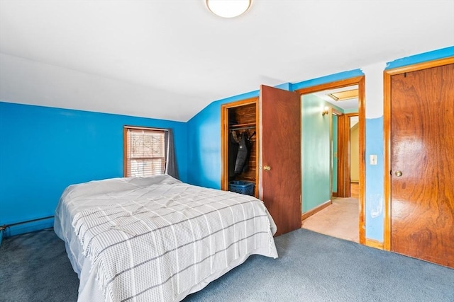 carpeted bedroom featuring lofted ceiling, a closet, and baseboard heating