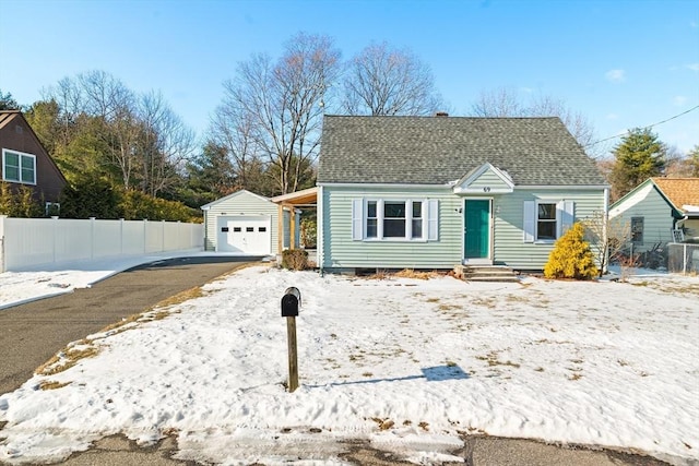 bungalow-style home featuring a garage and an outbuilding