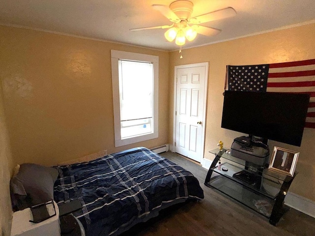 bedroom featuring baseboards, ornamental molding, a baseboard heating unit, and wood finished floors