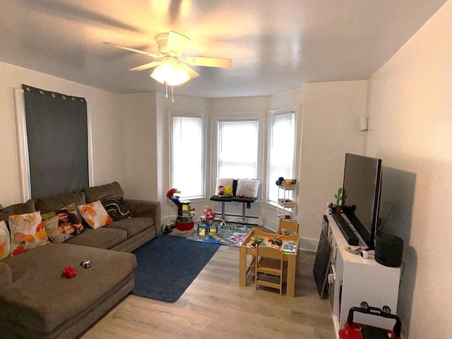 living area with ceiling fan and light wood-type flooring