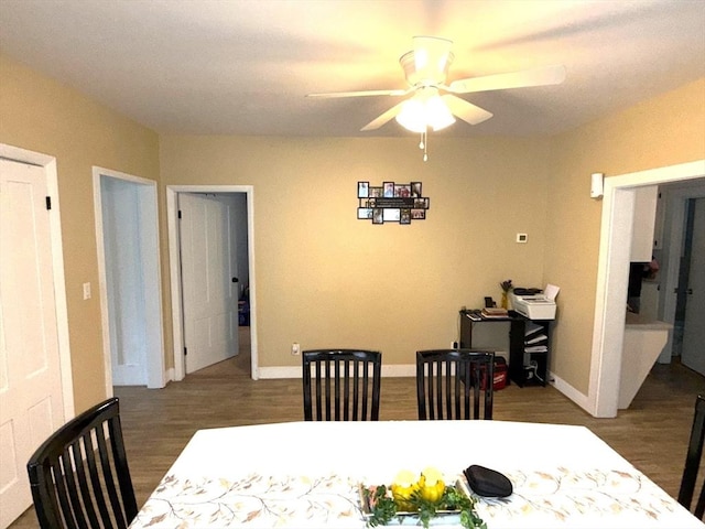 dining room featuring baseboards, a ceiling fan, and wood finished floors