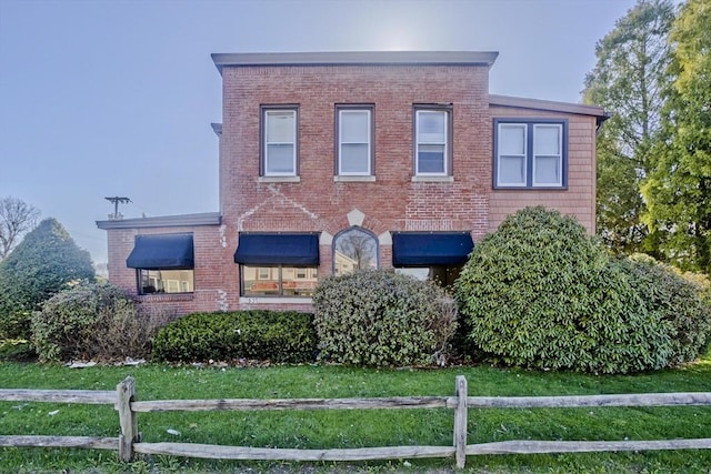 view of front of house with brick siding and fence