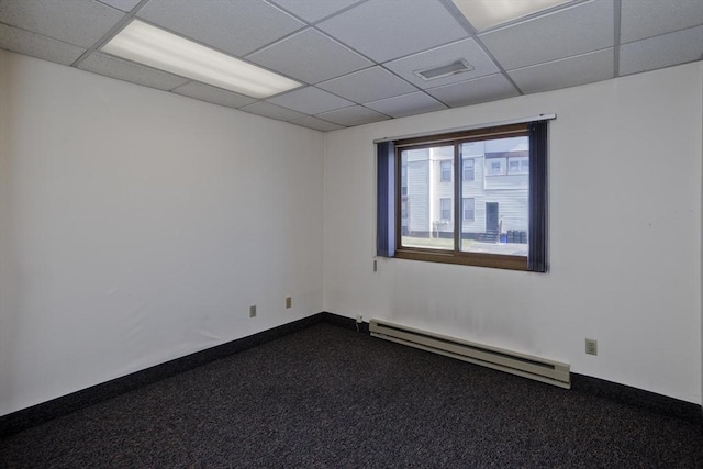 unfurnished room featuring a paneled ceiling, dark carpet, a baseboard radiator, and visible vents