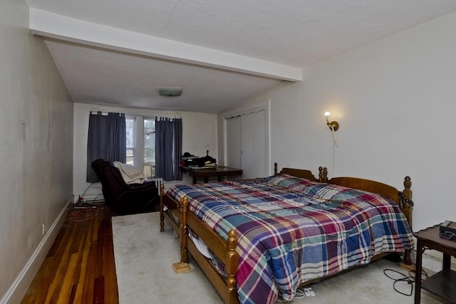 bedroom with lofted ceiling with beams, baseboards, and wood finished floors