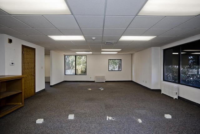 carpeted empty room featuring radiator, visible vents, and baseboards