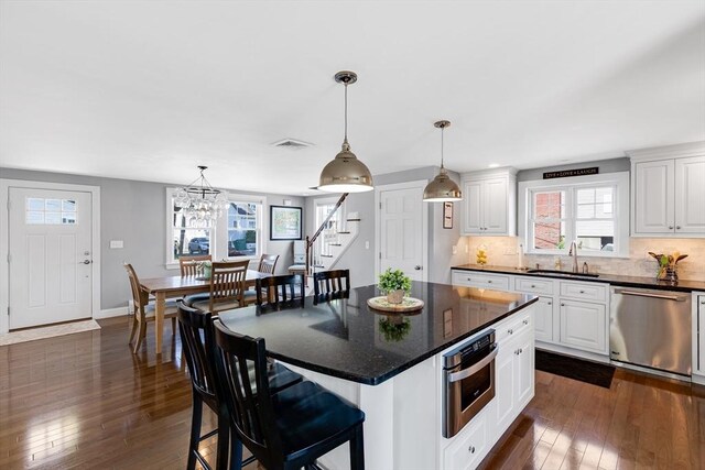 30 Millard Ave, Lynn, MA 01904 - kitchen featuring stainless steel appliances, dark wood-style flooring, white cabinetry, and decorative backsplash