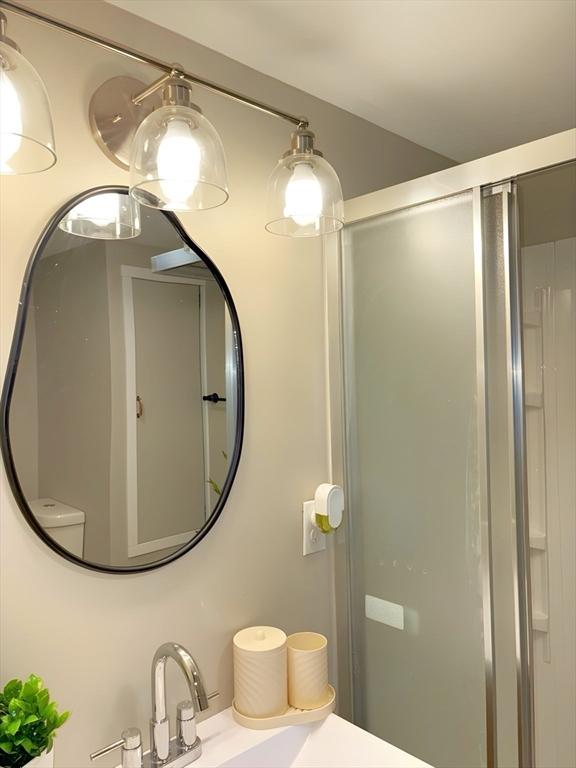 bathroom featuring an enclosed shower and sink