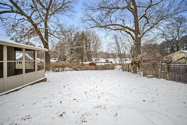 yard covered in snow with a sunroom