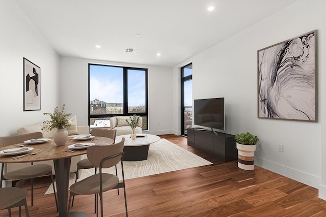 living room with baseboards, visible vents, wood finished floors, and recessed lighting