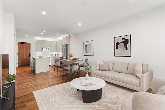 living area with light wood finished floors and recessed lighting