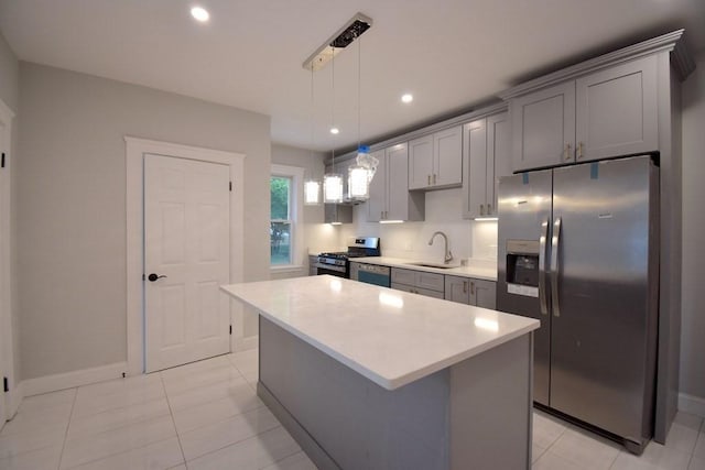 kitchen featuring appliances with stainless steel finishes, light countertops, gray cabinetry, pendant lighting, and a sink