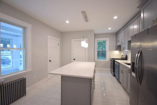 kitchen featuring appliances with stainless steel finishes, gray cabinets, light countertops, and radiator heating unit