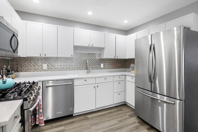 84 Tennis Plaza Rd Unit 46, Dracut, MA 01826 - kitchen with appliances with stainless steel finishes, a sink, light countertops, white cabinetry, and recessed lighting