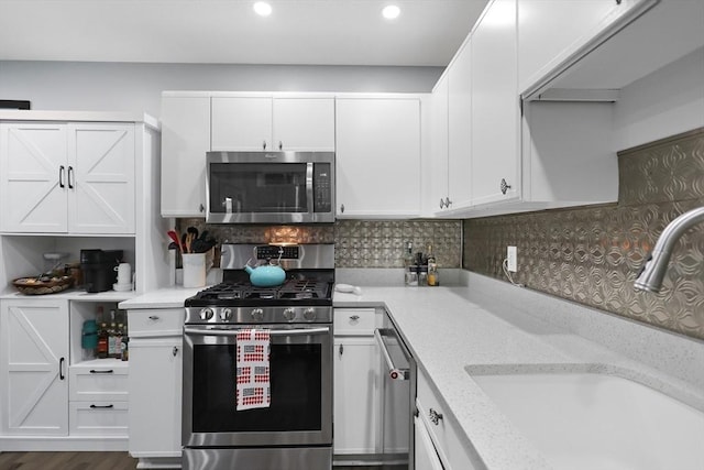 84 Tennis Plaza Rd Unit 46, Dracut, MA 01826 - kitchen featuring stainless steel appliances, a sink, white cabinets, recessed lighting, and decorative backsplash