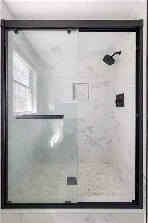 bathroom featuring a marble finish shower