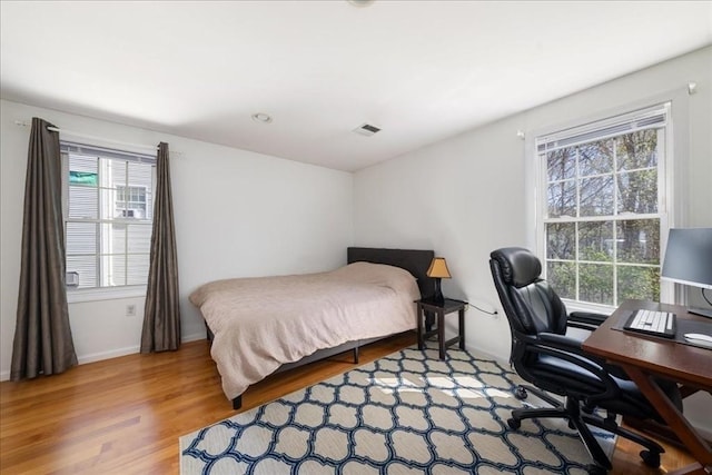 bedroom featuring visible vents and wood finished floors