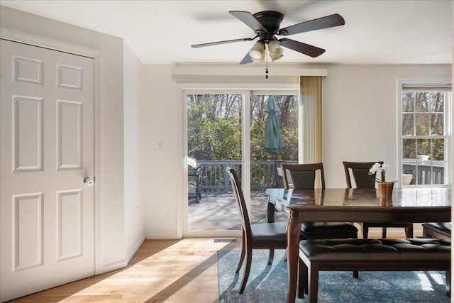 dining area with baseboards, ceiling fan, wood finished floors, and a healthy amount of sunlight