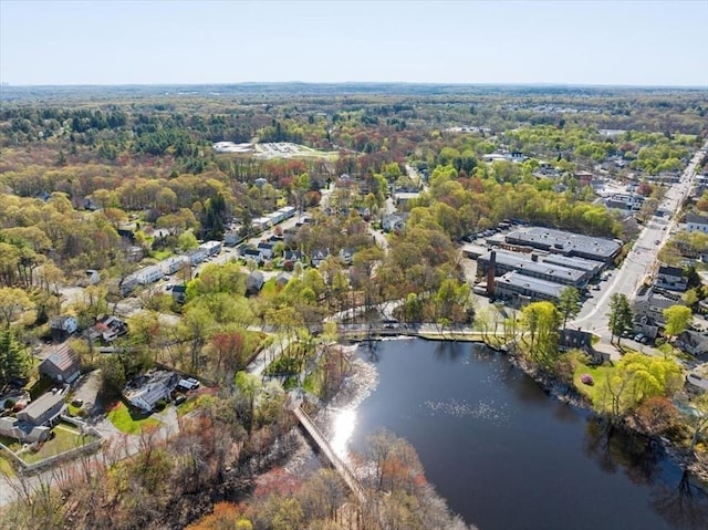 drone / aerial view with a water view and a forest view