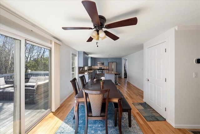 dining area with ceiling fan, baseboards, and light wood-style floors