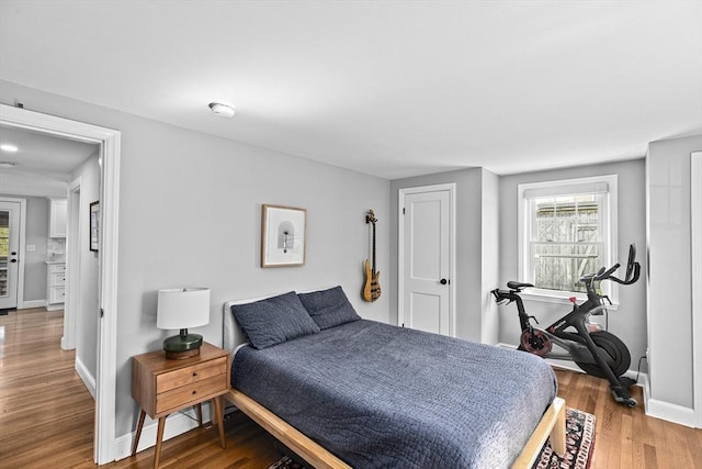 bedroom with baseboards and wood finished floors