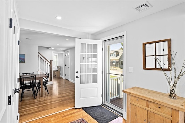 doorway with light wood-style flooring, recessed lighting, baseboards, visible vents, and stairway