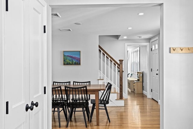 dining room with light wood-style flooring, recessed lighting, baseboards, visible vents, and stairway