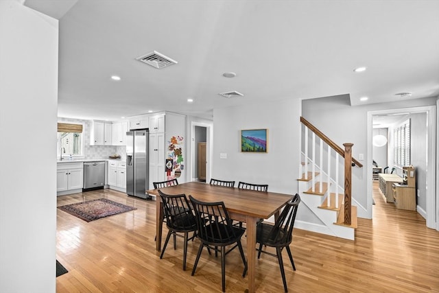 dining area featuring recessed lighting, light wood finished floors, stairs, and visible vents