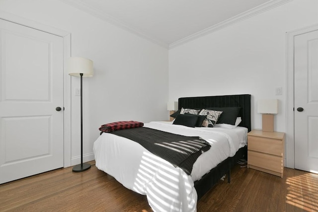 bedroom with crown molding and dark hardwood / wood-style floors