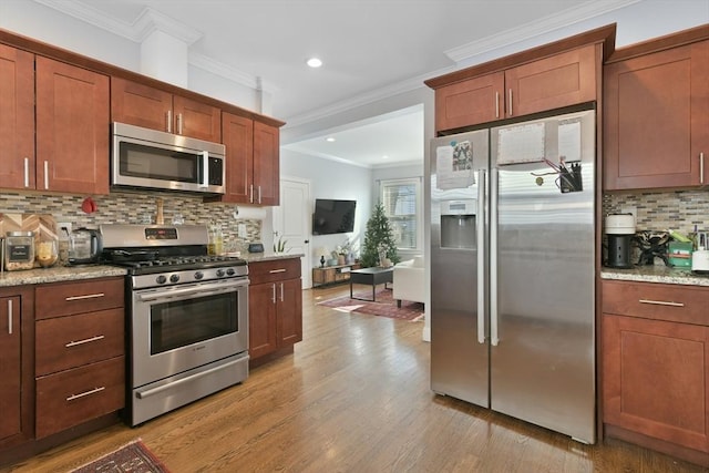 kitchen featuring tasteful backsplash, stainless steel appliances, and light stone countertops