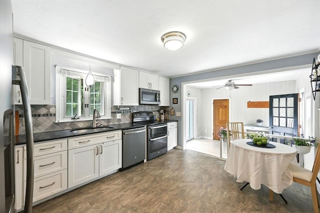 59 Searle Rd, South Hadley, MA 01075 - kitchen featuring stainless steel appliances, decorative backsplash, dark countertops, white cabinetry, and ceiling fan