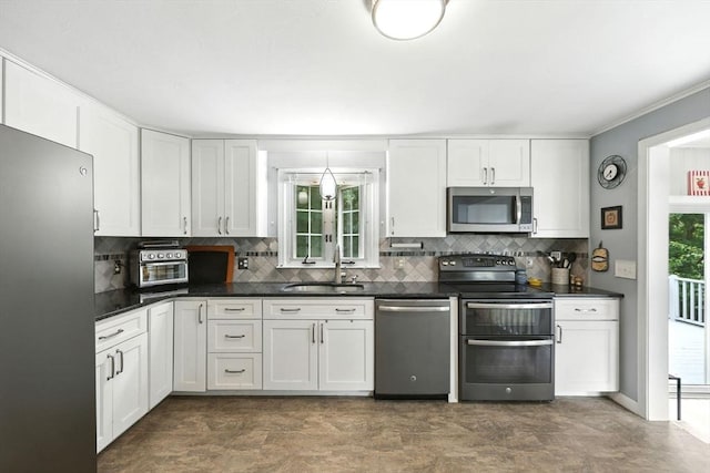 59 Searle Rd, South Hadley, MA 01075 - kitchen featuring stainless steel appliances, decorative backsplash, white cabinets, dark countertops, and crown molding