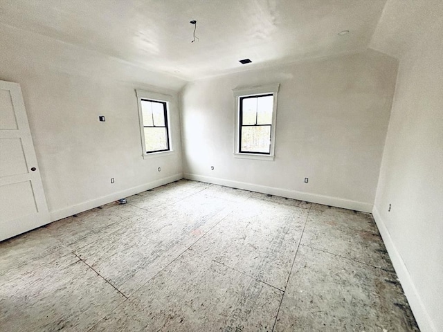 unfurnished room with lofted ceiling and baseboards