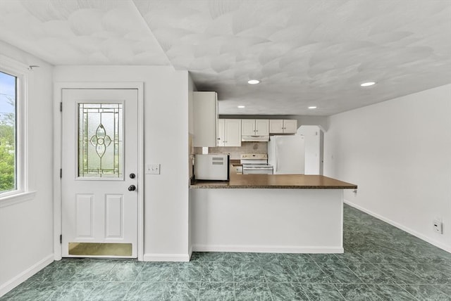 76 Choctaw Dr, Wareham, MA 02532 - kitchen featuring white appliances, dark countertops, white cabinets, a peninsula, and baseboards