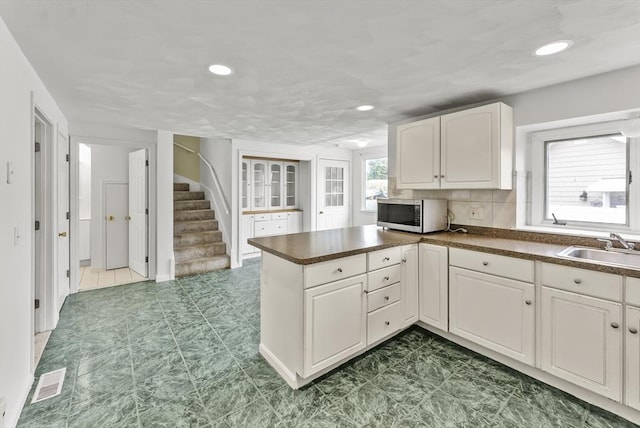 76 Choctaw Dr, Wareham, MA 02532 - kitchen featuring stainless steel microwave, a sink, a peninsula, dark countertops, and recessed lighting