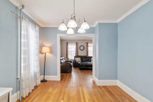 interior space featuring crown molding, wood-type flooring, and a chandelier