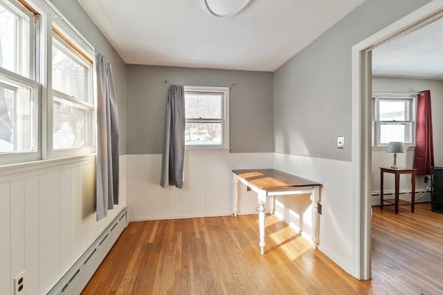 dining space featuring a baseboard heating unit and light hardwood / wood-style floors