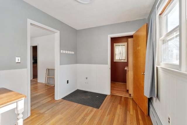 empty room featuring a baseboard radiator and light hardwood / wood-style floors