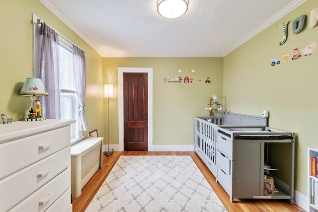 interior space with crown molding, radiator heating unit, a textured ceiling, and light wood-type flooring