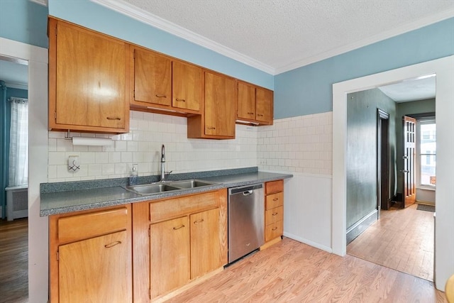 kitchen featuring radiator, dishwasher, sink, light hardwood / wood-style floors, and a textured ceiling