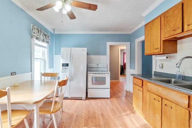 kitchen featuring sink, crown molding, tasteful backsplash, light wood-type flooring, and white appliances