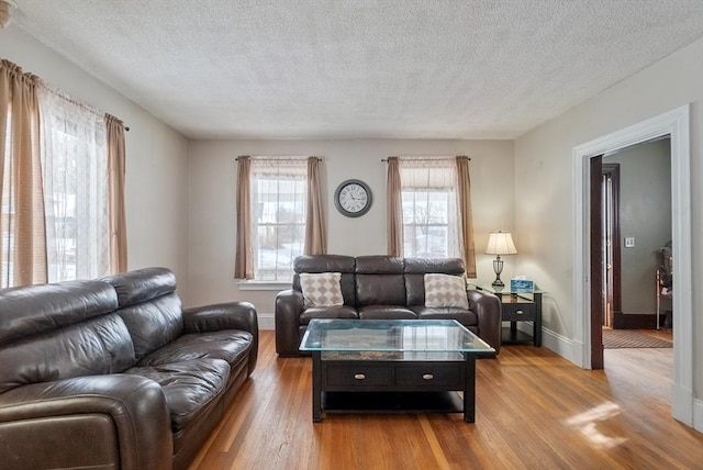 living room featuring a textured ceiling and light wood-type flooring