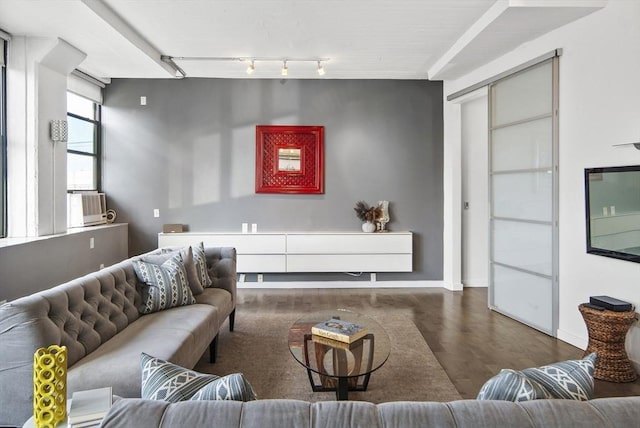 living room featuring cooling unit, baseboards, wood finished floors, and track lighting