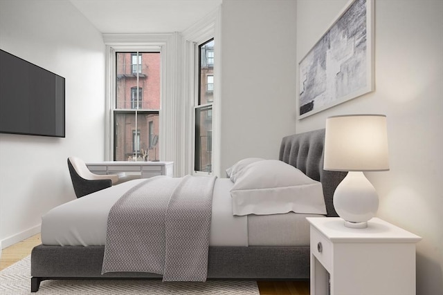 bedroom with baseboards and wood finished floors