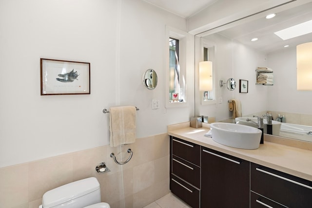 bathroom featuring vanity, toilet, tile walls, and tile patterned flooring