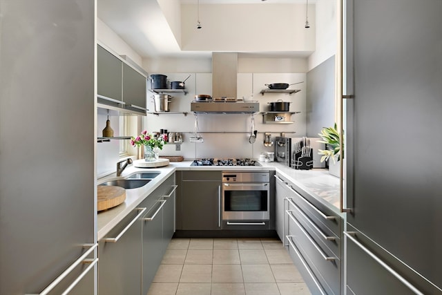 kitchen with appliances with stainless steel finishes, sink, island range hood, and gray cabinetry