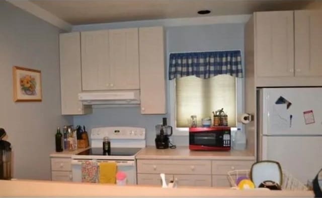 kitchen featuring white cabinetry and white appliances