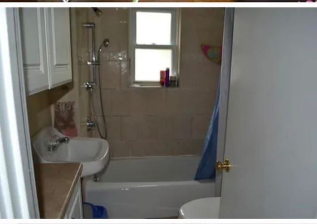 full bathroom featuring vanity, toilet, and shower / tub combo