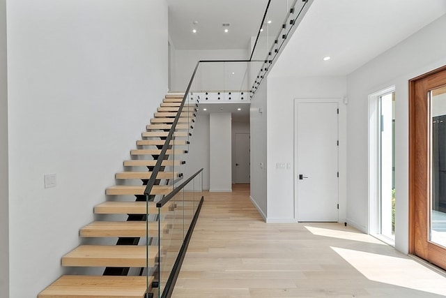 staircase with light hardwood / wood-style flooring